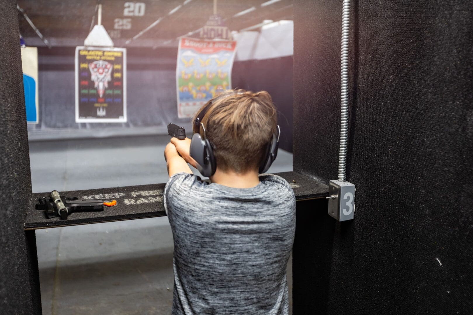 Child aiming at target in shooting range.